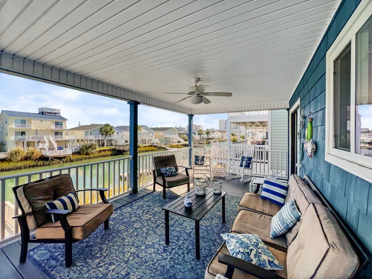 A comfortable seating area set outdoors with decorative cushions faces a beautiful water view. The space is perfect for lounging, entertaining, or simply soaking up the peaceful atmosphere, ideal for stargazing or hosting intimate gatherings by the water.
